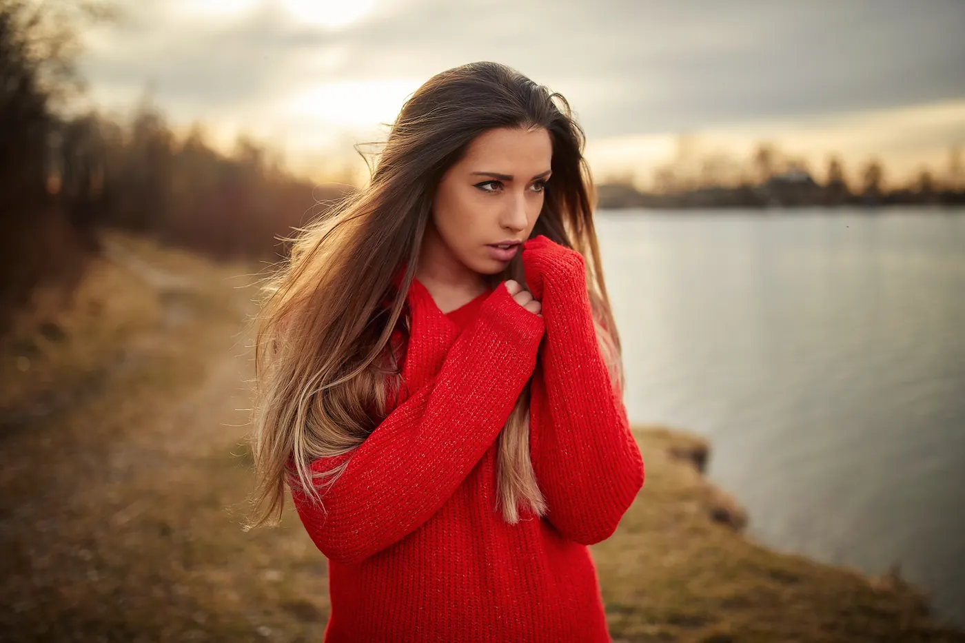 Porträt einer Frau im roten Pullover am See